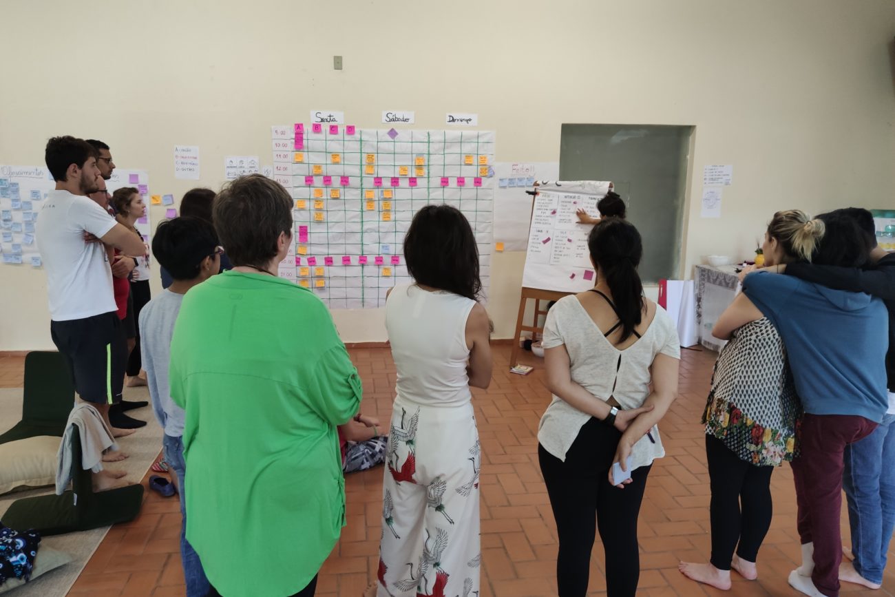 Participantes da Imersão em um grande salão montando a agenda de atividades.