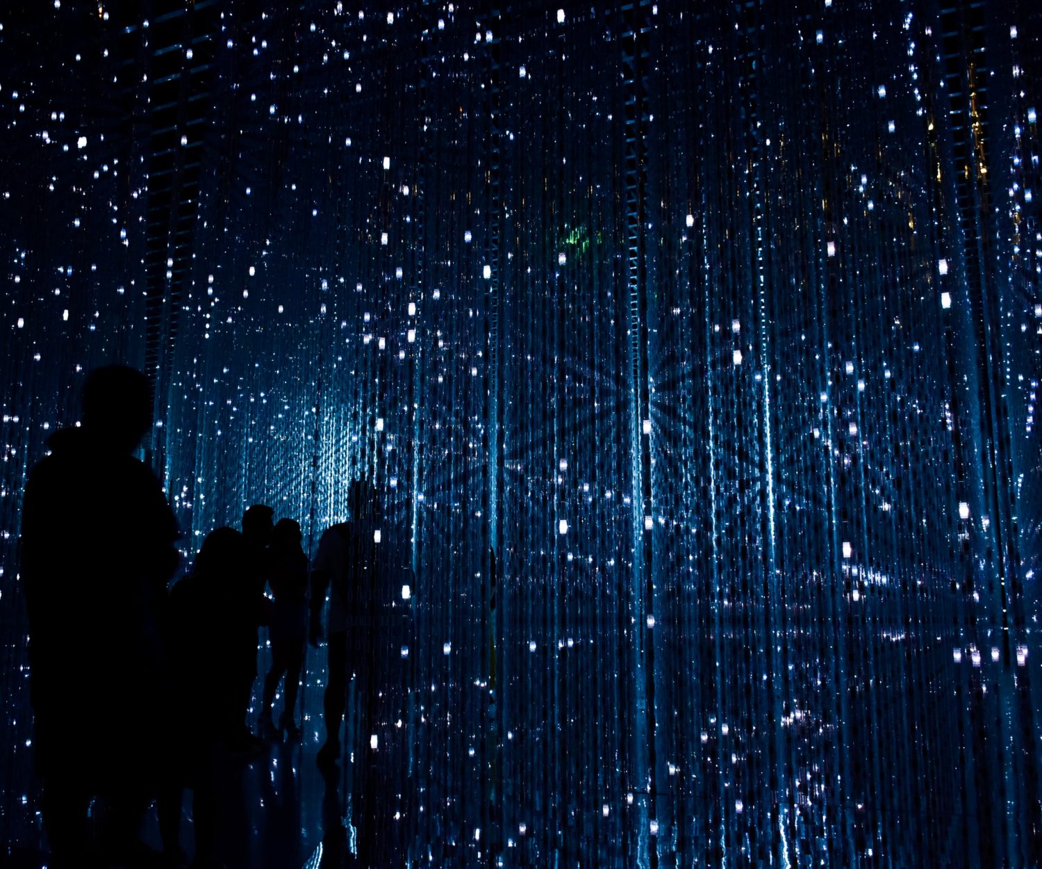 Silhuetas de pessoas caminhando em espaço azul futurista.